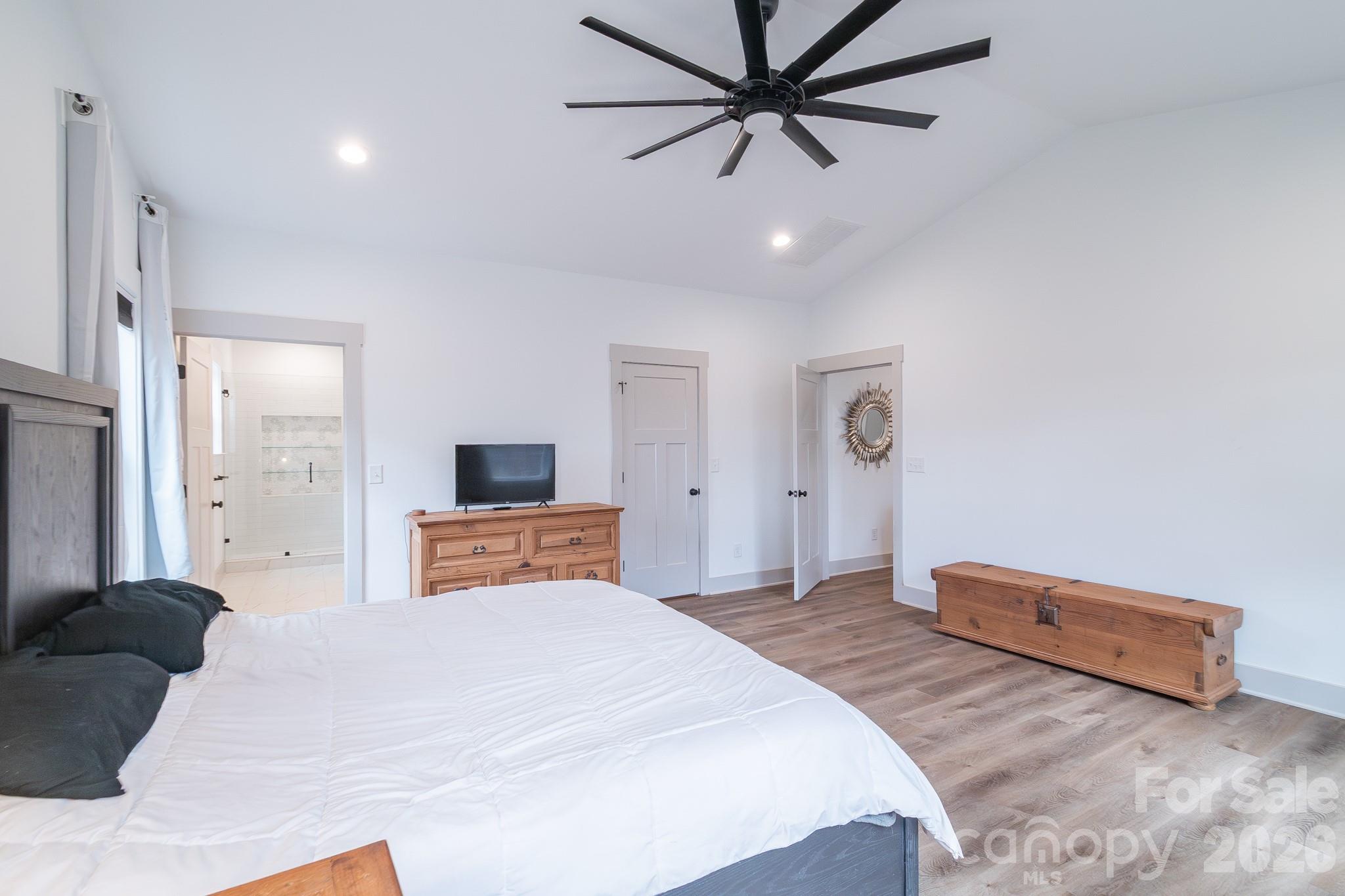 731 Miles Road Dallas, NC 28034 - Photo 23 of 45 a bedroom with a large bed and a chandelier