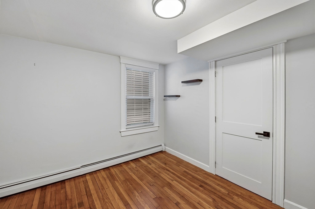 99 Mason Street, Unit 2 Salem, MA 01970 - Photo 13 of 25 a view of an empty room with wooden floor and a window