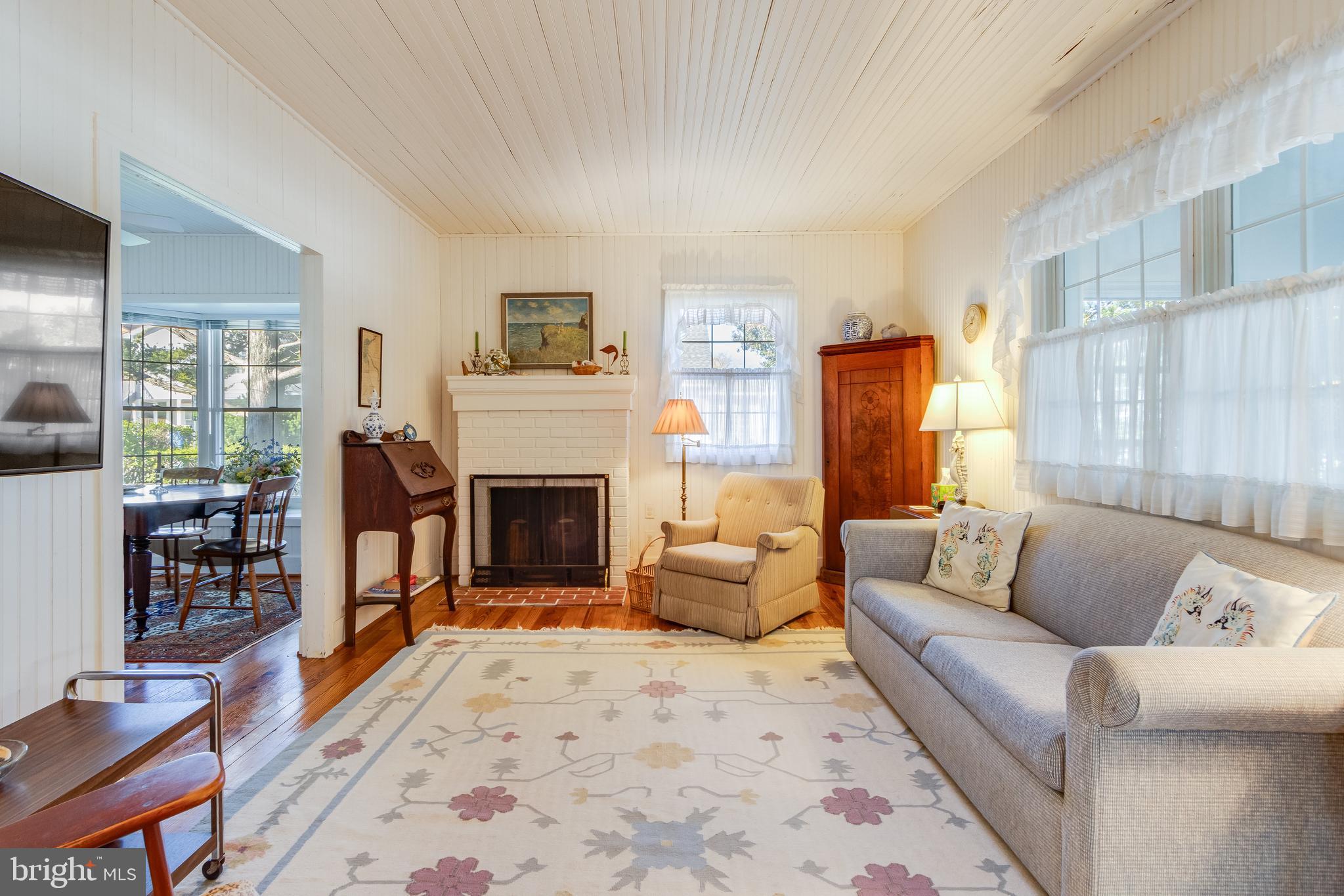 28 Delaware Avenue Rehoboth Beach, DE 19971 - Photo 19 of 44 a living room with furniture a fireplace and a large window