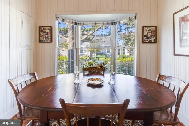 a dining room with furniture window and wooden floor