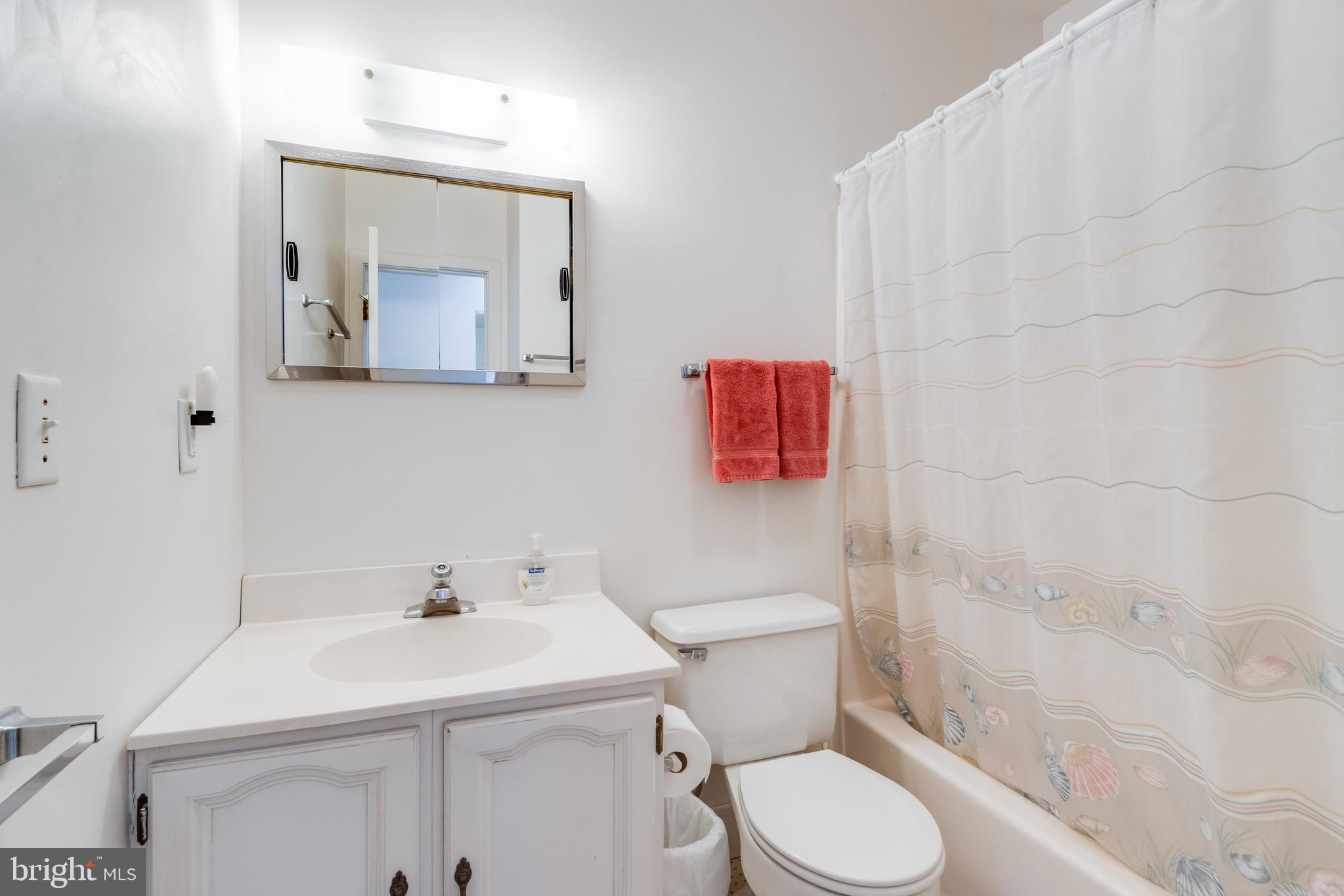 28 Delaware Avenue Rehoboth Beach, DE 19971 - Photo 34 of 44 a bathroom with a toilet sink and mirror
