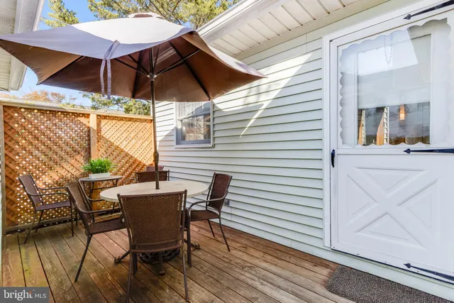 a view of a patio with a table and chairs under an umbrella