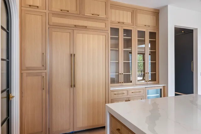 a view of an empty room with wooden floor and cabinet