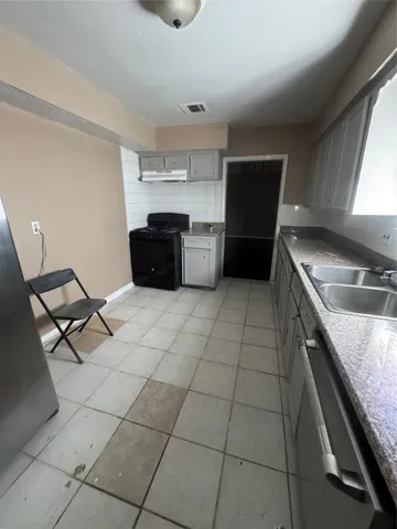 a kitchen with stainless steel appliances granite countertop a sink and a stove