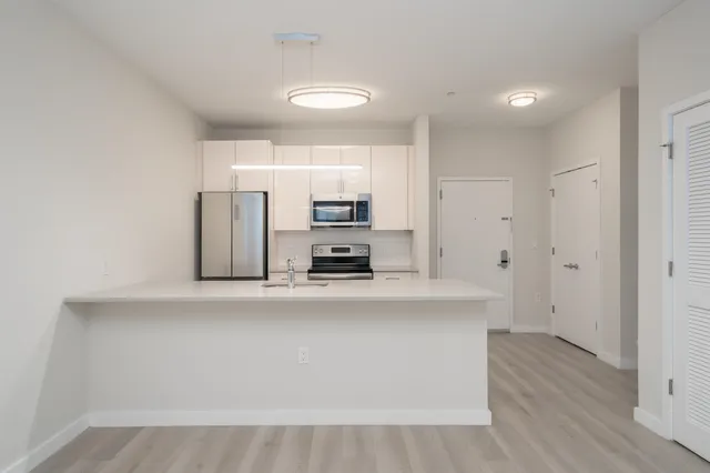 a large white kitchen with stainless steel appliances