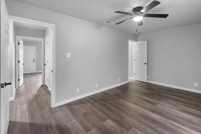 an empty room with wooden floor a ceiling fan and closet