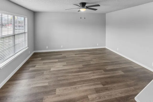 wooden floor in an empty room with a window