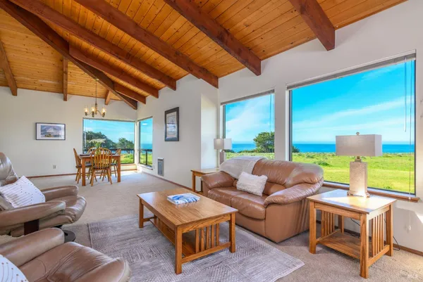 a living room with furniture a fireplace and a floor to ceiling window