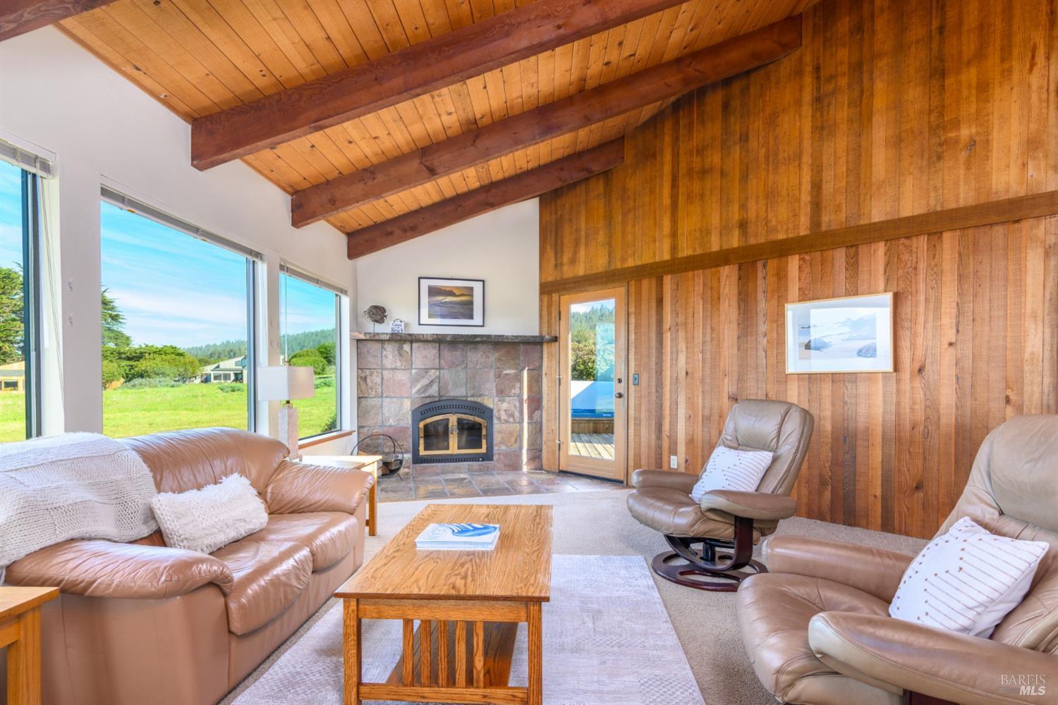 39153 Curlew Reach The Sea Ranch, CA 95497 - Photo 13 of 31 a living room with furniture a fireplace and a floor to ceiling window