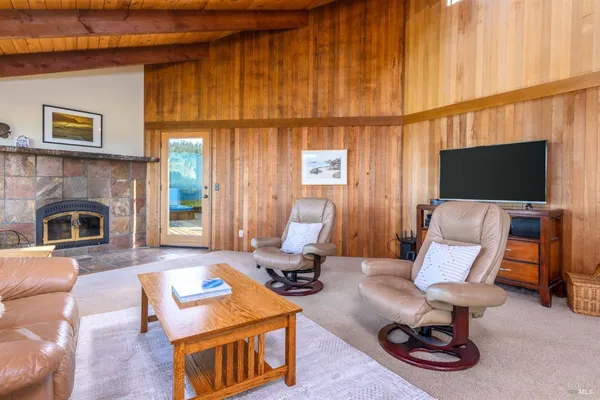 a dining room with furniture a kitchen view and wooden floor