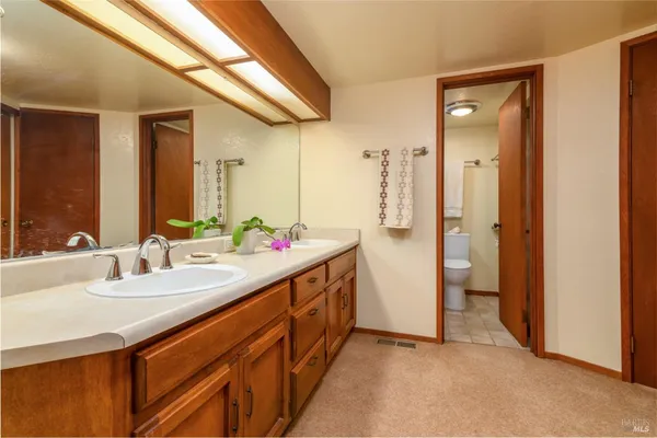 a bedroom with a bed and dresser with mirror