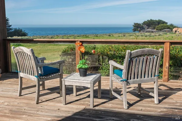a view of a balcony with wooden floor and outdoor seating