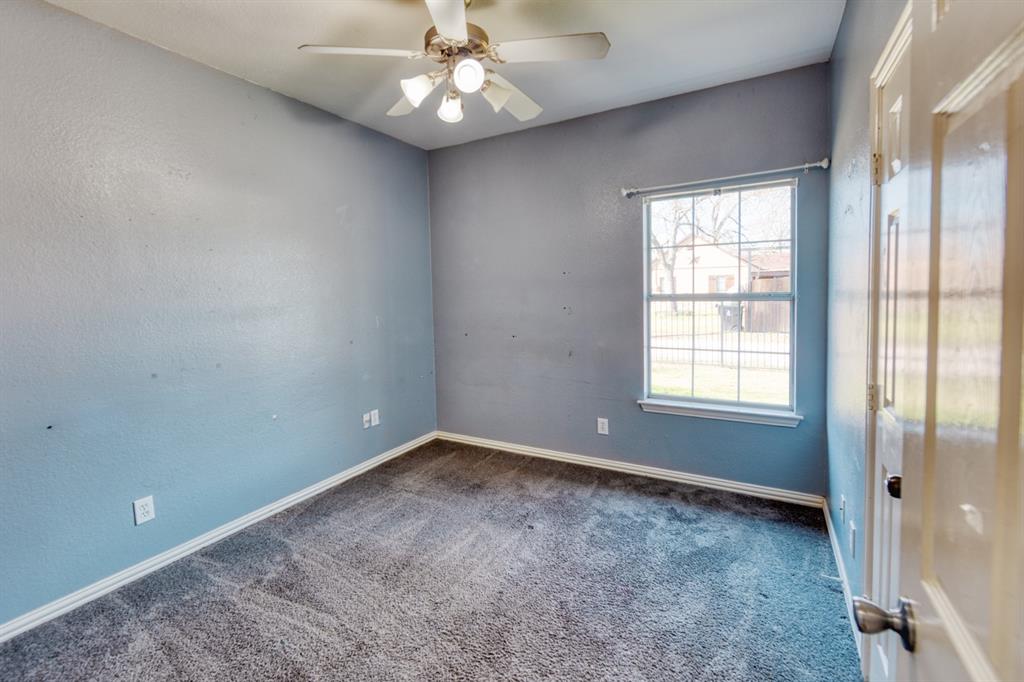 216 East Walcott Street Pilot Point, TX 76258 - Photo 7 of 12 wooden floor in an empty room with a window