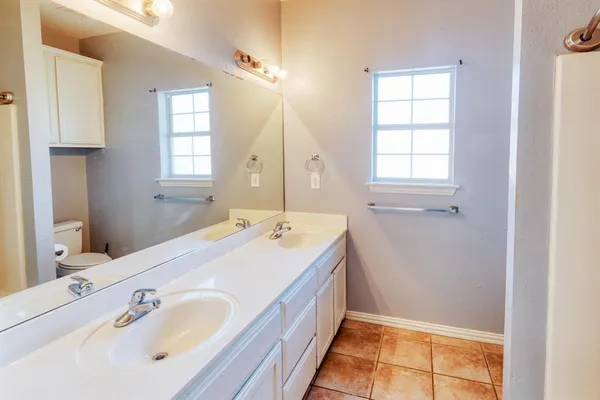 a spacious bathroom with a tub sink and mirror