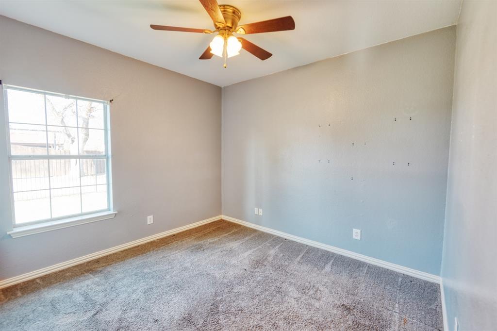 216 East Walcott Street Pilot Point, TX 76258 - Photo 9 of 12 an empty room with a window and a fan