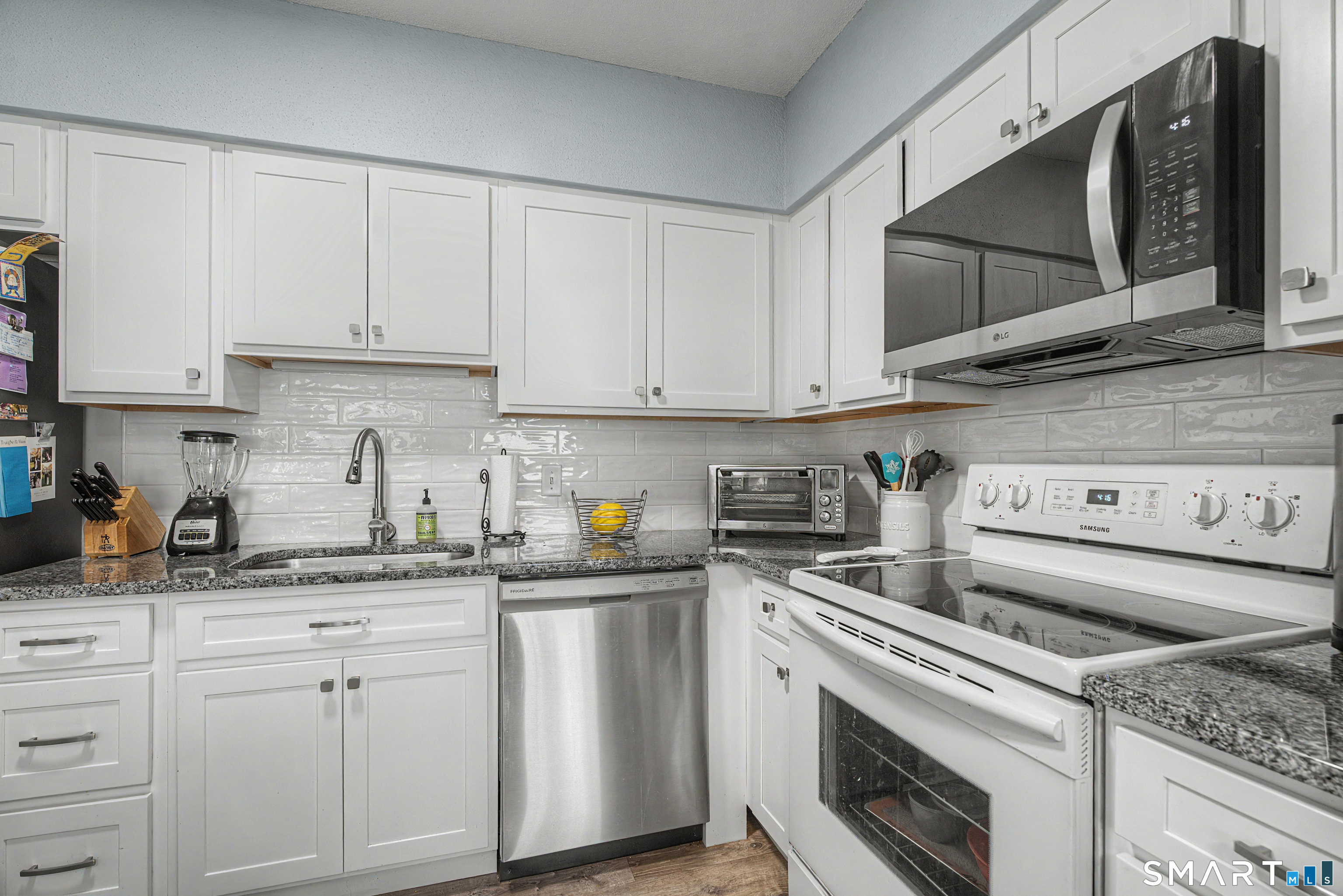 900 Mix Avenue, Unit 60 Hamden, CT 06514 - Photo 3 of 21 a kitchen with granite countertop white cabinets sink and stainless steel appliances