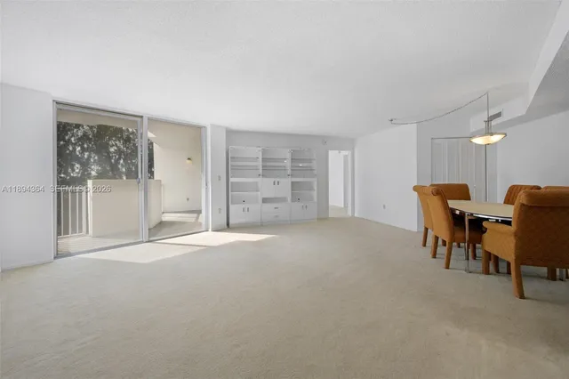 a view of a livingroom with furniture and a refrigerator