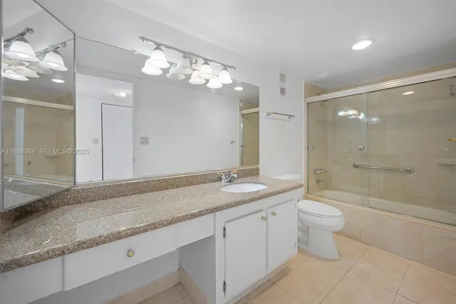 a bathroom with a granite countertop sink a toilet and bathtub