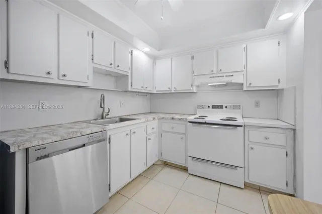 a kitchen with granite countertop white cabinets and white appliances