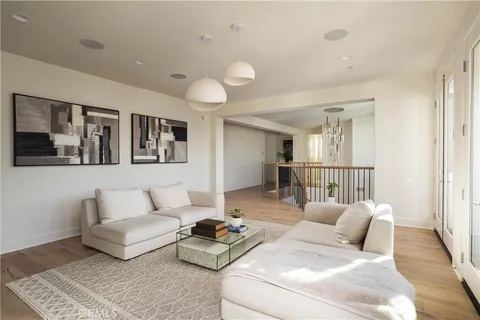 a living room with furniture and a view of kitchen