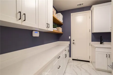 a kitchen with white cabinets and a sink