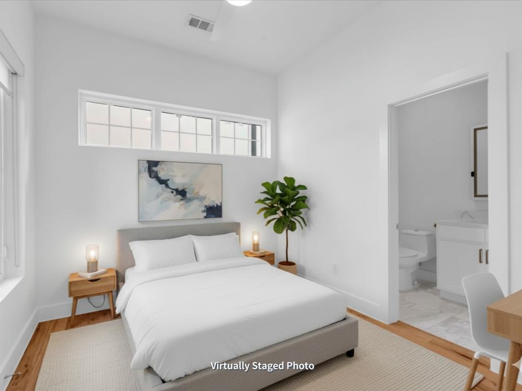 1910 Caddo Street, Unit A205 Dallas, TX 75204 - Photo 18 of 36 a spacious bedroom with a bed and a potted plant