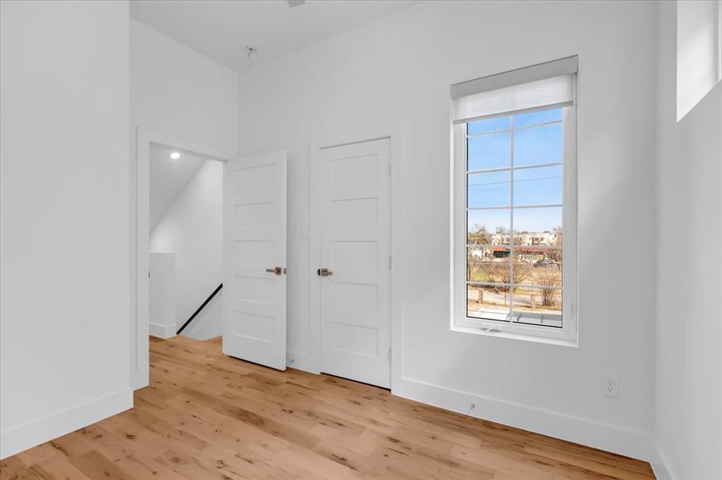 1910 Caddo Street, Unit A205 Dallas, TX 75204 - Photo 21 of 36 a view of an empty room with wooden floor and a window