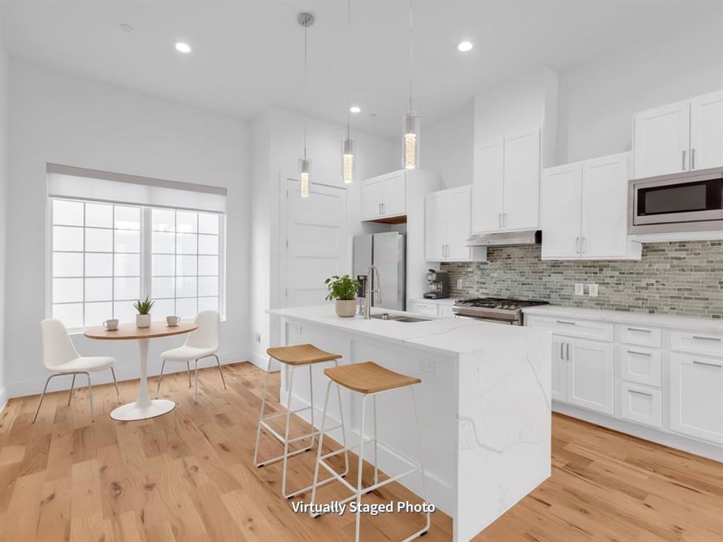 1910 Caddo Street, Unit A205 Dallas, TX 75204 - Photo 8 of 36 a large kitchen with kitchen island a stove a sink a counter space and cabinets