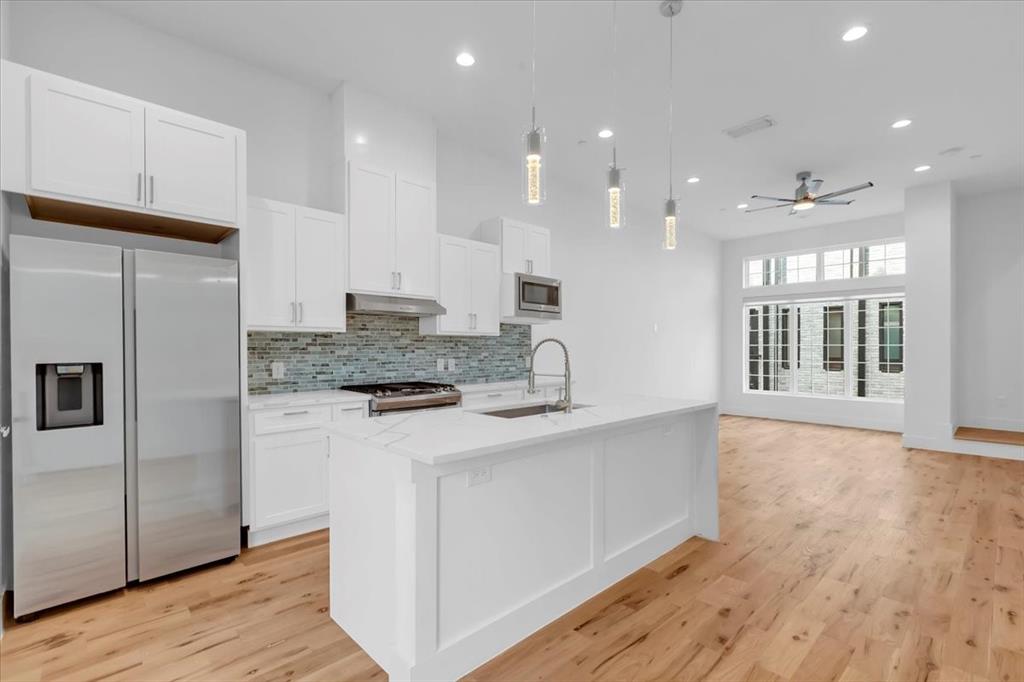 1910 Caddo Street, Unit A205 Dallas, TX 75204 - Photo 10 of 36 a kitchen with kitchen island a counter top space cabinets and stainless steel appliances
