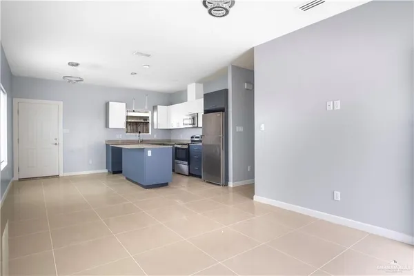 a large kitchen with stainless steel appliances a sink a counter top space cabinets and a window