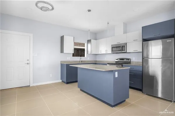 a kitchen with stainless steel appliances granite countertop a refrigerator a stove a sink and a refrigerator