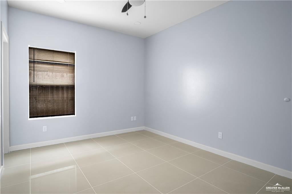 2013 Stardust Lane, Unit 1 Edinburg, TX 78541 - Photo 7 of 17 Empty room with light tile patterned floors and a ceiling fan