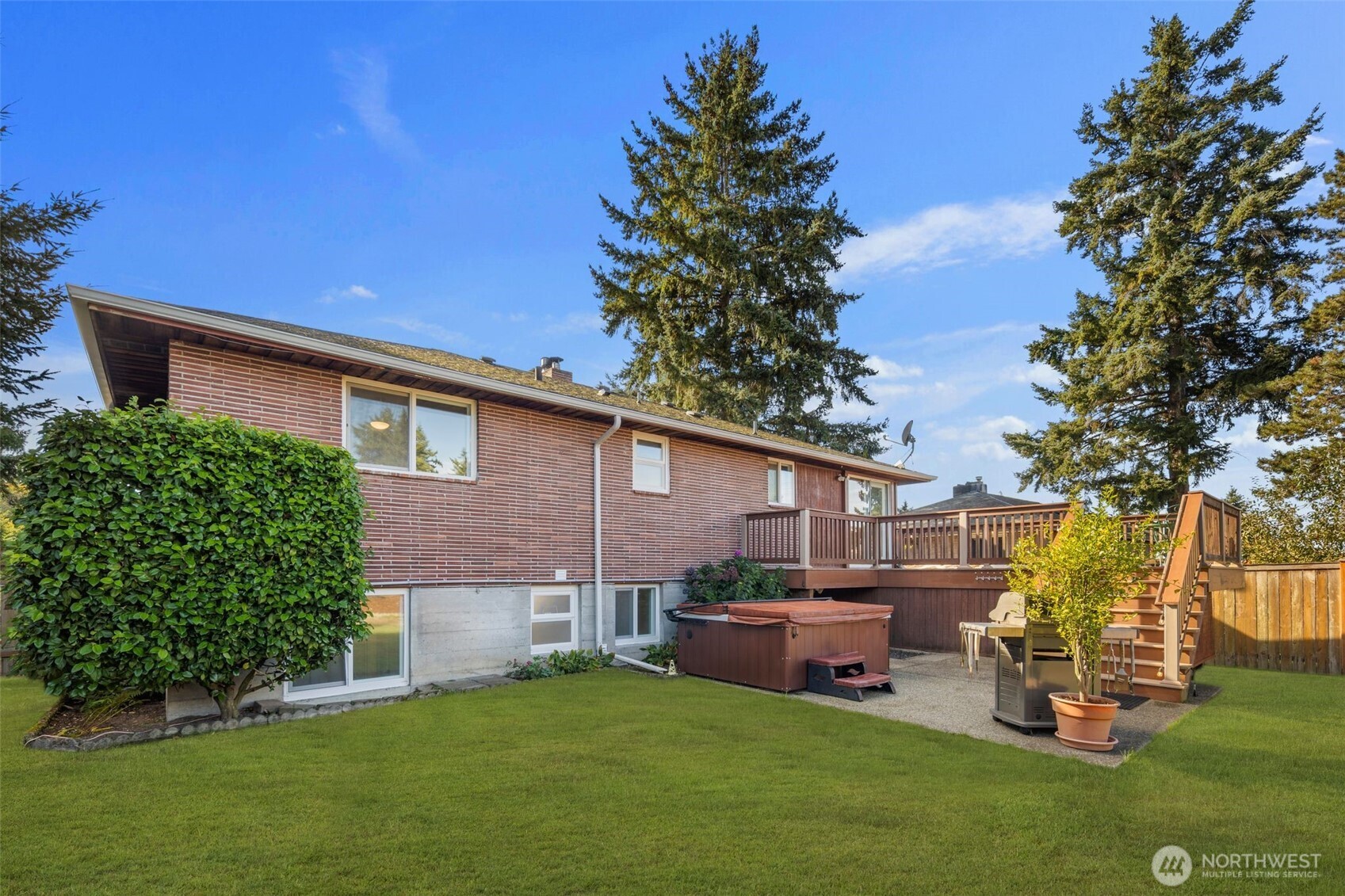 1212 South 230th Street Des Moines, WA 98198 - Photo 26 of 32 a view of a backyard with table and chairs potted plants and a large tree