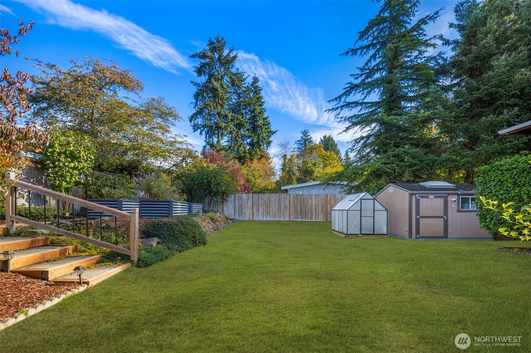1212 South 230th Street Des Moines, WA 98198 - Photo 28 of 32 a view of a backyard with a garden and trees
