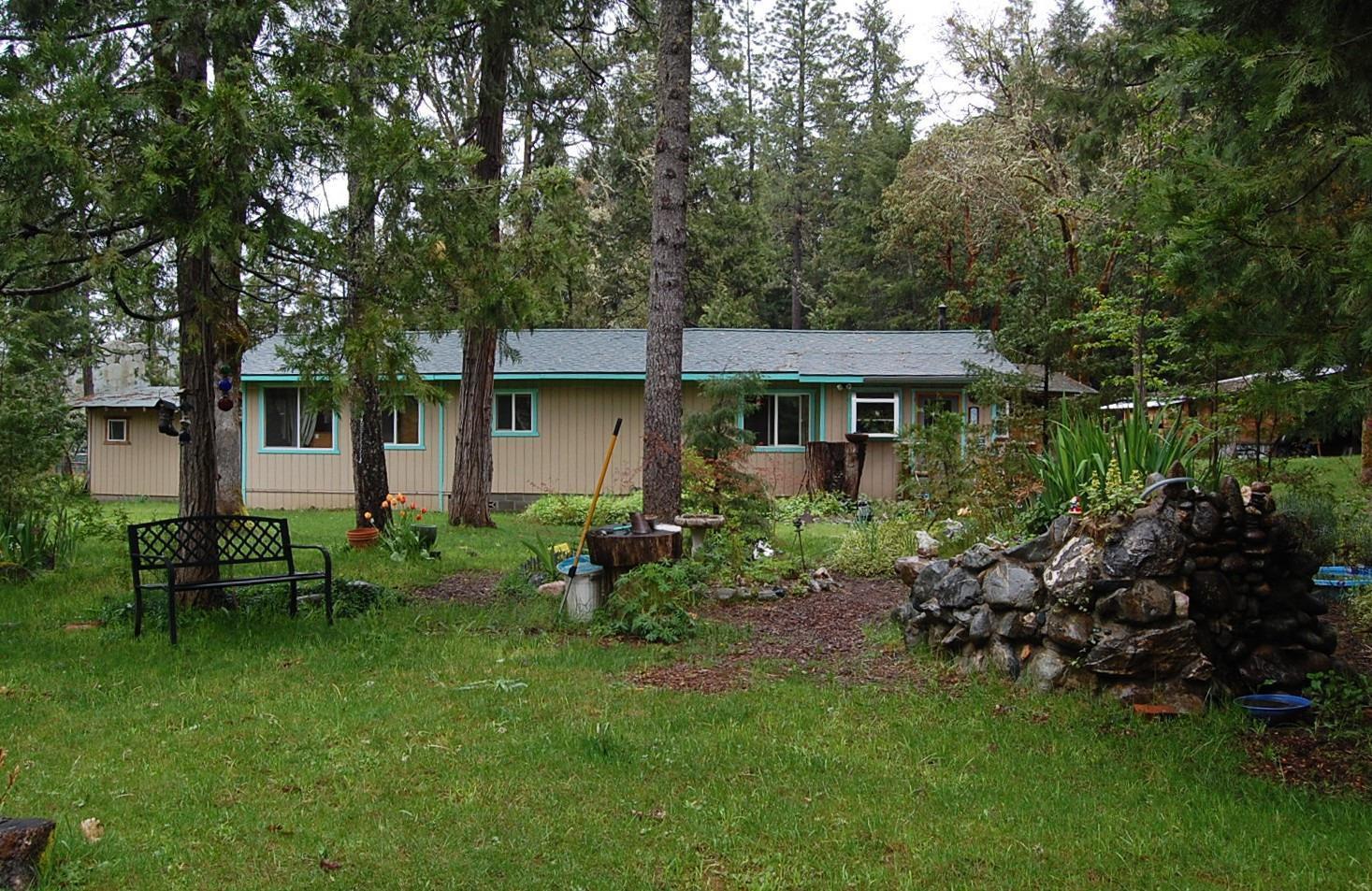 310 Page Creek Road Cave Junction, OR 97523 - Photo 1 of 31 Side view of home surrounded by trees