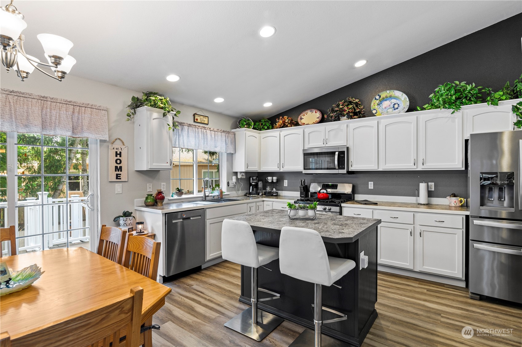 2502 97th Place Southeast Everett, WA 98208 - Photo 9 of 29 a kitchen with kitchen island granite countertop wooden floors and white cabinets