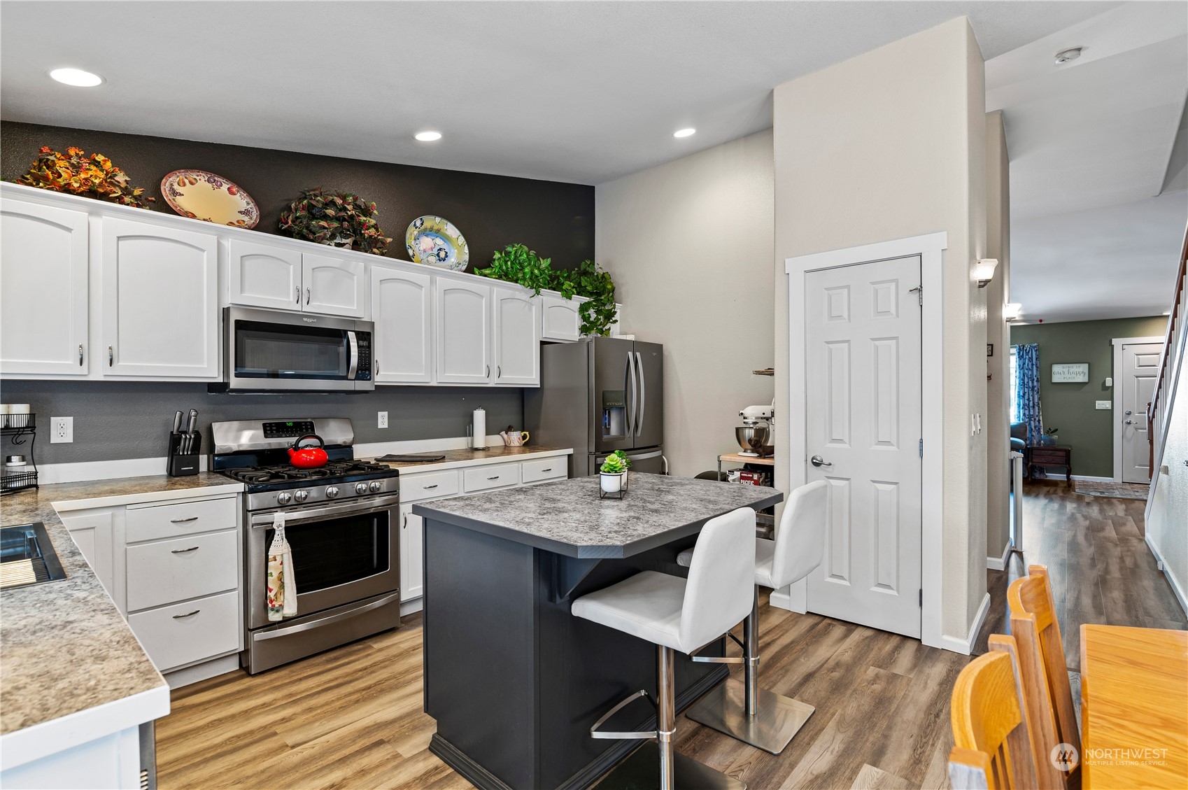 2502 97th Place Southeast Everett, WA 98208 - Photo 10 of 29 a kitchen with stainless steel appliances granite countertop a stove top oven a sink dishwasher and white cabinets with wooden floor
