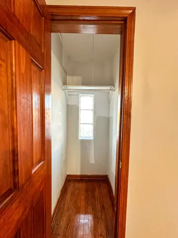 a view of a small space with wooden floor and a window