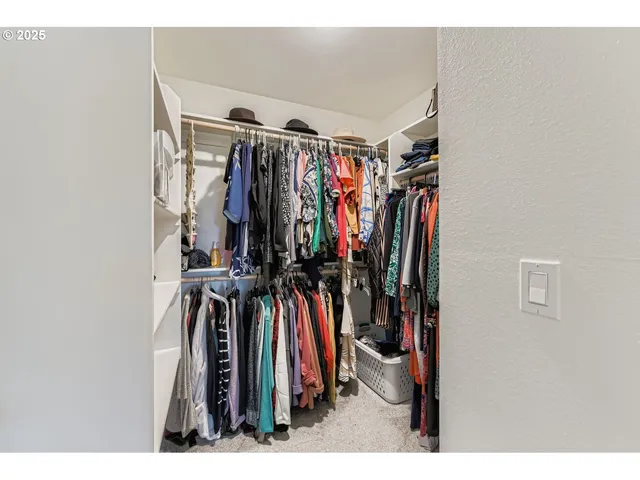 a view of walk in closet with clothes