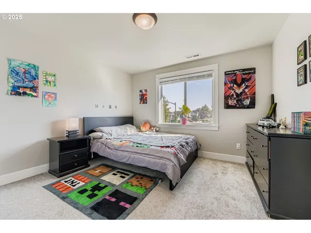 a bedroom with a bed window and painting on the wall