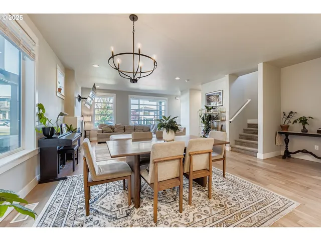 a dining room with wooden floor a chandelier a wooden table and chairs