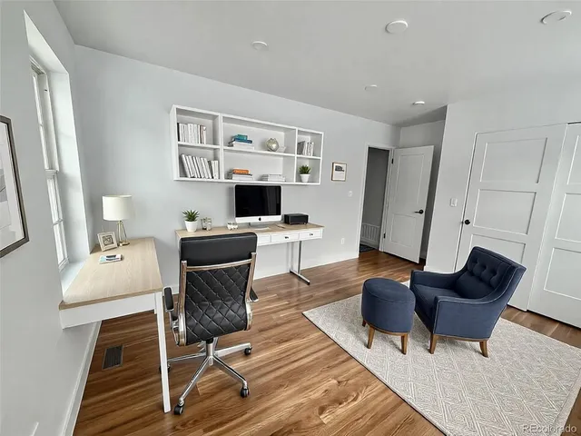 a work room with furniture wooden floor and a window