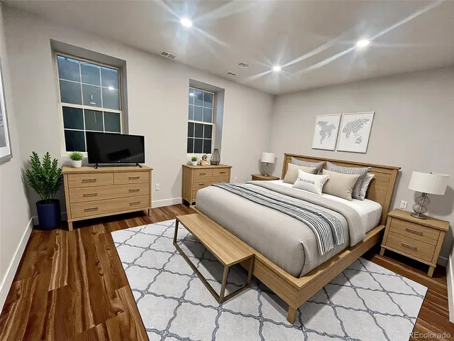 a bedroom with a bed and a flat tv screen on dresser