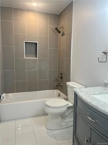a bathroom with a granite countertop toilet a sink and bathtub