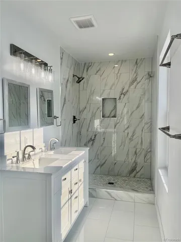 a bathroom with a double sink shower and a mirror