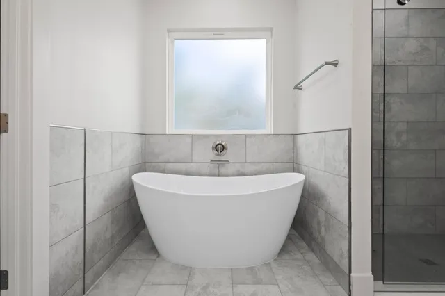 a spacious bathroom with a double vanity sink a large mirror and a shower