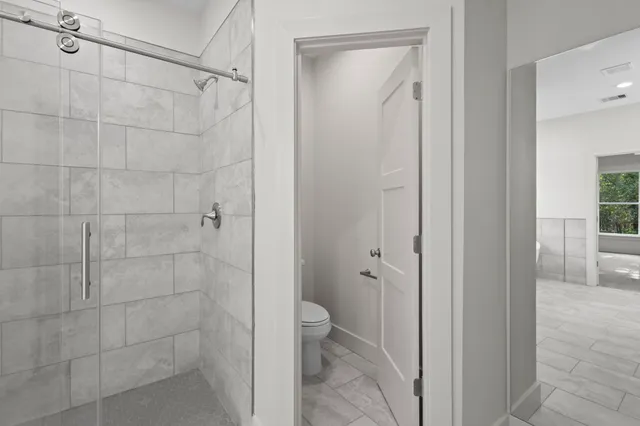 a view of an empty room with a window and a ceiling fan
