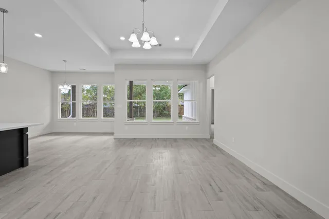 a large white kitchen with kitchen island a sink dishwasher a stove and a refrigerator with wooden floor