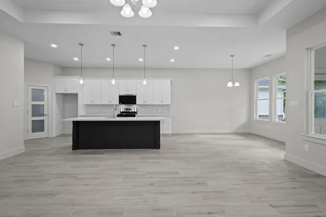 a view of kitchen with granite countertop sink and refrigerator