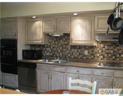 39 Warrenville Road Middlesex, NJ 08846 - Photo 3 of 23 a kitchen with a sink a stove a microwave and cabinets